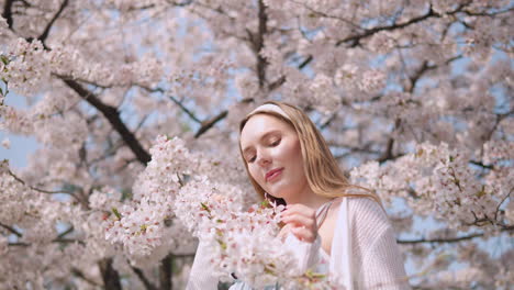 Chica-Caucásica-Tocando-Las-Hermosas-Flores-De-Sakura-En-El-Parque-En-Seocho,-Seúl,-Corea-Del-Sur.