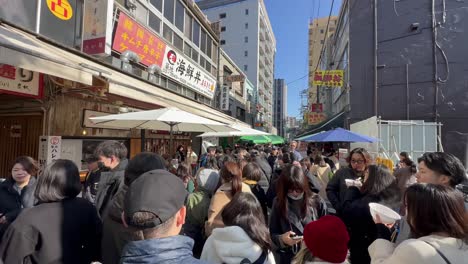 Tourist-filming-the-crowds-at-Tsukiji-Fish-Market,-Tokyo-Japan