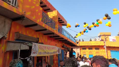 pov-shot-In-the-bazaar-on-the-other-side-of-the-temple,-the-bazaar-has-been-decorated-very-nicely-by-the-temple-employees-with-black-red-pink-and-different-balloons-and-police