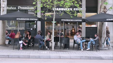 Kunden-Sitzen-Draußen-Auf-Der-Terrasse-Des-Amerikanischen-Multinationalen-Starbucks-Cafés-In-Spanien