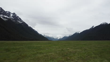 Racing-over-the-golden-tussock-grasslands-towards-the-Eglinton-Valley,-Fiordland-in-New-Zealand