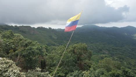Schwenk-Von-Rechts-Nach-Links-Durch-Die-Kolumbianische-Flagge-Mit-Den-Bergen-Der-Sierra-Nevada-Im-Hintergrund