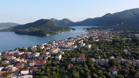 Aerial-drone-video-of-famous-seaside-village-and-port-of-Nydri-famous-for-trips-to-Ionian-islands-and-nearby-beaches,-Lefkada,-Greece