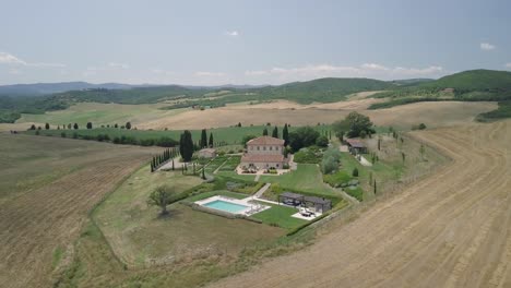 aerial-view-of-Villa-San-Luigi-a-unique-and-historical-Tuscan-residence,-with-swimming-pool-resort-up-on-cypress-hill