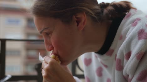 Detail-Shot-of-Woman-Eating-Arepas-Homemade-in-Pajamas-on-Cozy-Balcony-Delight