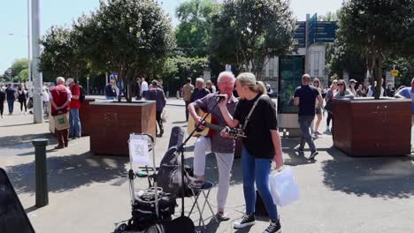 Musikalische-Harmonie-Auf-Der-Grafton-Street,-Als-Eine-Frau-In-Die-Melodie-Eines-Straßenkünstlers-Einstimmt