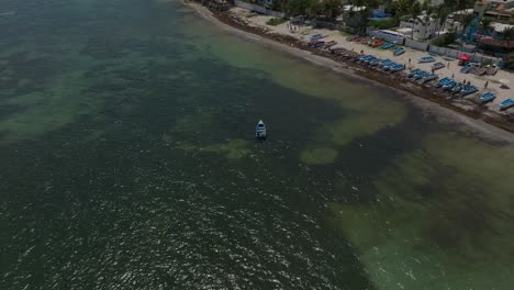 Boats-moored-along-beach-of-Guayacanes,-San-Pedro-de-Macoris