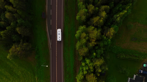 Von-Oben-Nach-Unten-Aufgenommene-Drohne-über-Einem-Wohnmobil,-Das-Auf-Einer-Asphaltstraße-Fährt,-Sommerabend-In-Lappland