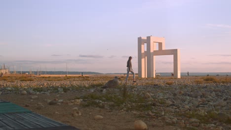 Female-Tourist-Walking-By-The-500-Years-Of-Le-Havre-Monumental-Sculpture-On-The-Beach-In-France