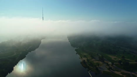 Flying-Over-The-River-With-Calm-Waters-On-A-Misty-Morning