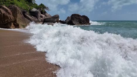 The-spectacle-of-waves-crashing-upon-the-shores-of-Koh-Samui,-Thailand,-is-captured-in-slow-motion