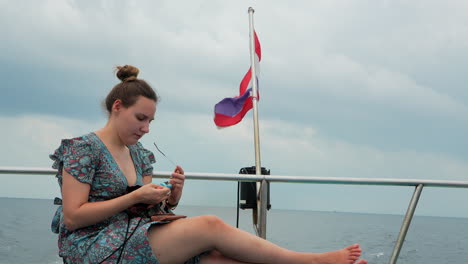 Pretty-woman-cleaning-sunglasses-on-a-ferry-of-Thailand