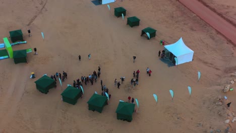 Vista-Aérea-De-Personas-En-El-Evento-Ecotrail,-Noche-En-Al-Ula,-Arabia-Saudita---Dando-Vueltas,-Disparo-De-Drone