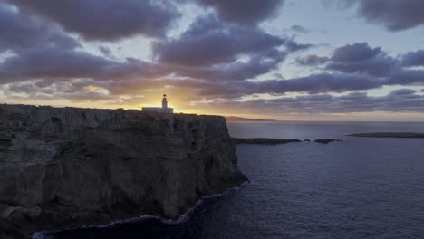 Cliff-coastal-landscape-sun-shining-below-Menorca-coastal-lighthouse-aerial-drone-panning-slow-motion