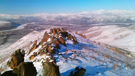 sunny-weather,-snowy-mountain-and-rocks-on-it,-bird's-eye-flight