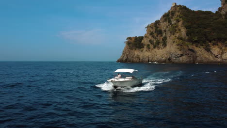 Luftaufnahme-Eines-Bootes-Umkreist-Vor-Dem-Leuchtturm-Von-Portofino-Im-Sonnigen-Italien