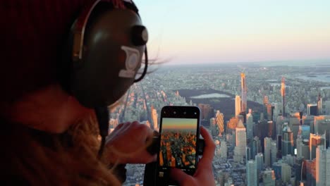 Mujer-Tomando-Fotografías-Del-Centro-De-Manhattan-Desde-Un-Helicóptero,-Puesta-De-Sol-En-Nueva-York