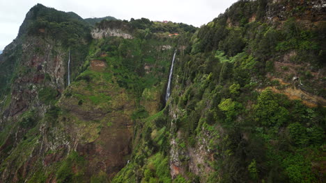 Flying-towards-waterfall-in-green-mountains,-Rocha-do-Navio,-Madeira,-Portugal