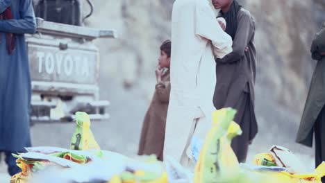 Profile-view-of-a-small-Pakistani-boy-standing-in-Iftar-Drive-for-food-Distribution-to-Poor-People-of-Balochistan,-Pakistan