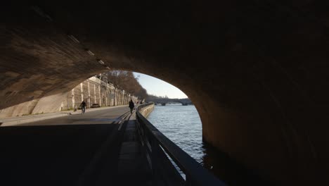 Romantic-Seine-river-walkway-under-bridge-in-Paris-on-sunny-day
