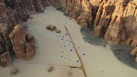 Luftaufnahme-Eines-Blauen-Punktkunstwerks-Inmitten-Von-Sandsteinbergen-In-Der-Wüste-X-Alula,-Saudi-Arabien