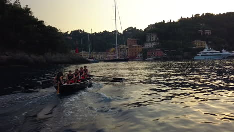 Aerial-view-of-a-rowing-boat,-moving-toward-Portofino,-sunny-evening-in-Italy