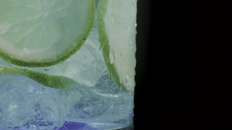 Lemon-infused-ice-cold-drink-in-a-glass,-set-against-a-sleek-black-background