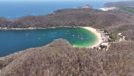 Aerial-view-of-Playa-Maguey-bustling-with-boats-and-people