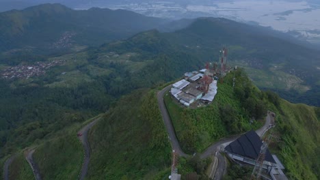 Torres-De-Internet-En-La-Cima-De-La-Montaña-Y-El-Majestuoso-Paisaje-De-Indonesia-Abajo,-Vista-Aérea