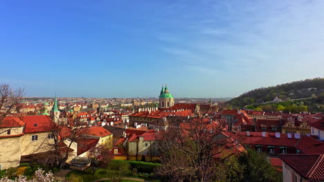 Panoramic-still-view-of-Prague-city-with-red-rooftops,-green-dome,-and-blue-skyline
