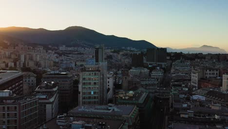 Aerial-view-flying-low-over-the-cityscape-of-San-Vincenzo,-Genova,-sunset-in-Italy
