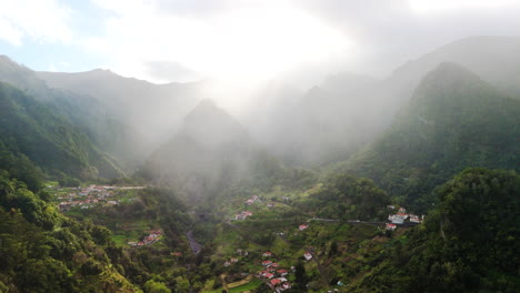 hazy-morning-on-green-mountain-mist-valley,-sunshine-on-Madeira-nature,-aerial-drone-fly-view