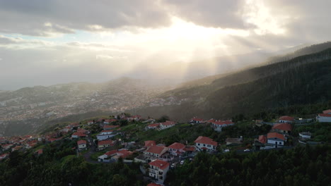 Funchal,-Madeira-coast,-mountains,-aerial-establishment-shot,-sun-shines-on-portugese-island