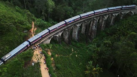 Aerial-view-around-a-train-on-the-Nine-Arch-Bridge,-in-cloudy-Sri-Lanka,-Asia