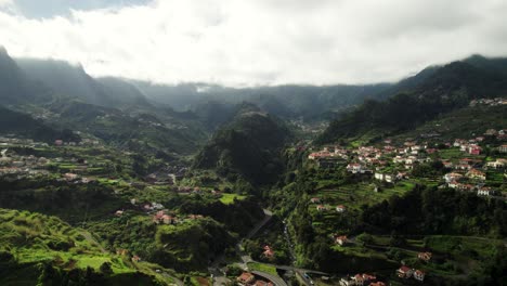Aerial-Footage-of-Madeira-Landscape-with-Mountains,-Canyons,-Village-on-Cloudy-Day