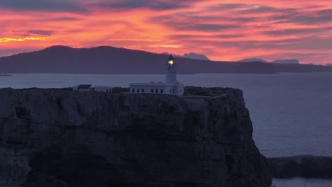 Aerial-panoramic-lightning-Cavalleria-lighthouse-Menorca-Scenic-viewpoint-dramatic-sea-view,-sunset-golden-pink-gradient-skyline