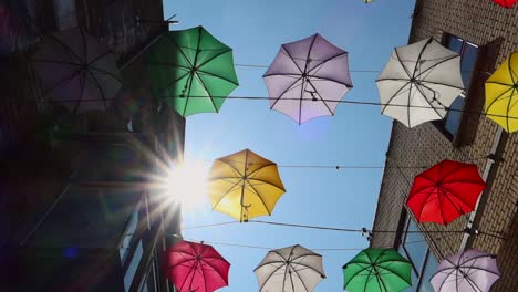 Sunflare-arises-between-colorful-decorative-umbrellas-on-Anne's-Lane,-Dublin