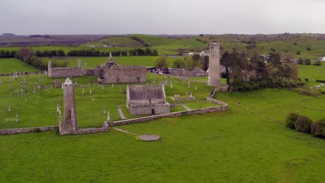 Dynamic-aerial-shot-approaches-old-round-towers-and-buildings-at-Clonmacnoise