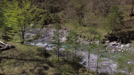 4K-Aerial-Drone-Fly-along-Idyllic-River-with-Crystal-Clear-Turquoise-Water-with-Camp-Fire-place-next-to-it