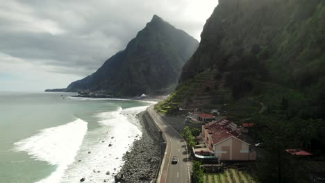 Aerial-of-Scenic-Road,-Coastline,-Waves,-Steep-Mountains,-Driving-Cars