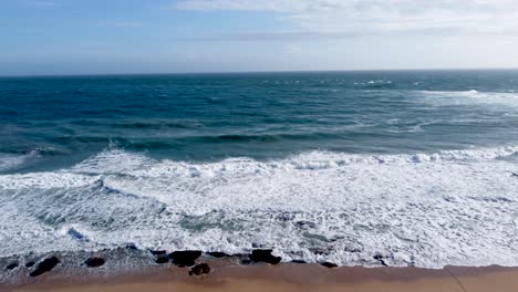 Waves-crashing-on-seashore-with-blue-color