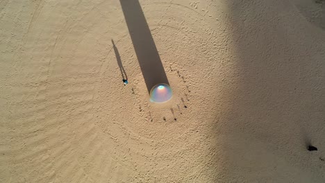 Aerial-view-above-the-Gisela-Colon-parabolic-monolith-and-a-man,-at-the-Desert-x-art-collection,-in-sunny-Al-ula,-Saudi-Arabia---top-down,-drone-shot