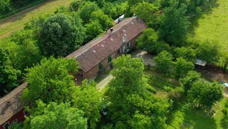 Aerial-view-away-from-winery,-in-sunny,-Piemonte,-Italy---pull-back,-drone-shot