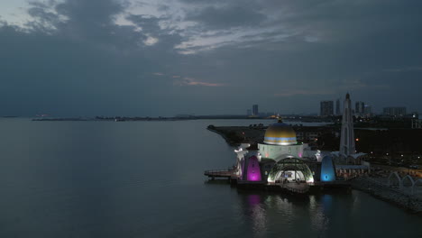 Masjid-Selat-Melaka-Lighting-Up-In-The-Early-Evening-Drone-Pull-Back