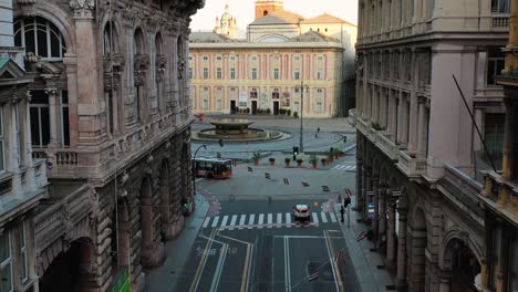 Aerial-view-in-middle-of-old-buildings,-revealing-he-Piazza-de-Ferrari-square-and-fountain-in-Genova-city,-sunny-morning-in-Italy