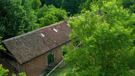 Vista-Aérea-Sobre-Una-Bodega-En-Medio-De-árboles-En-Piamonte,-Italia---Dando-Vueltas,-Disparo-De-Drone