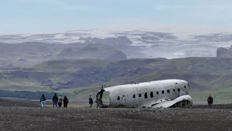 Drohnenaufnahme-Eines-Verlassenen-US-Marineflugzeugs-Auf-Island-Mit-Gletschern-Und-Hügeln-Im-Hintergrund