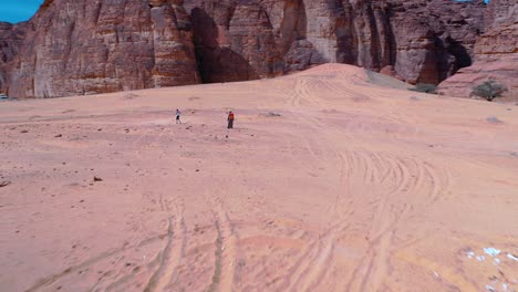 Aerial-view-following-people-running-at-the-Ecotrail-event,-in-sunny-Al-Ula,-Saudi-Arabia---circling,-drone-shot