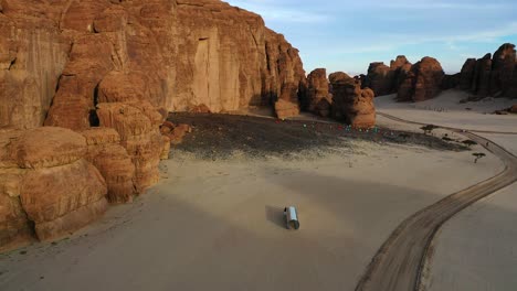 Aerial-view-of-the-Amma-Qabl-metallic-tube-set,-at-Desert-X-AlUla,-Saudi-Arabia---rotating,-pull-back,-drone-shot