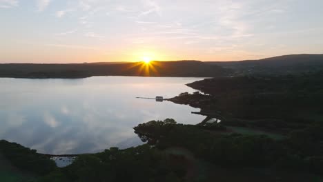 Panoramic-sunset-islet-wet-Fornells-bay,-Menorca-aerial-green-coastline-horizon